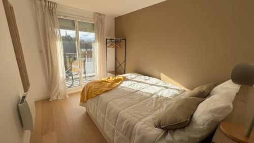 a bedroom with a bed and a window at Le Panorama, confortable appartement - accès direct à la plage in Bernières-sur-Mer