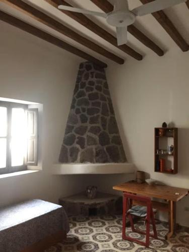 a bedroom with a bed and a table and a window at Casa Moser in Stromboli