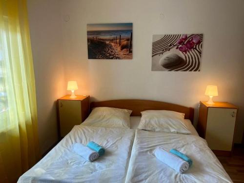 a bedroom with a bed with two towels on it at Olive Garden Krk in Brzac