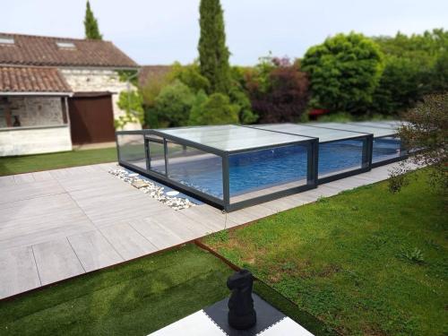 una casa in vetro con piscina in un cortile di Gite de Marthon, 10 personnes a Marthon