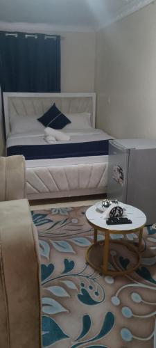 a small bedroom with a bed and a table at Utawala studio apartment in Nairobi