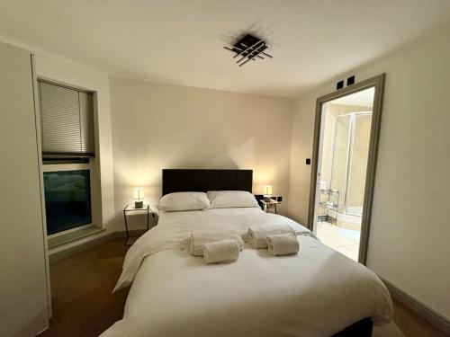 ein Schlafzimmer mit einem großen weißen Bett mit zwei Kissen in der Unterkunft Modern 2-Bed Flat in York City Centre - Steps from Christmas Market in York