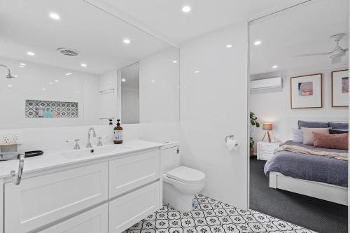 黄金海岸Tropical Oasis Heated Spa, Pool and Huge Decks的带水槽、马桶和床的浴室