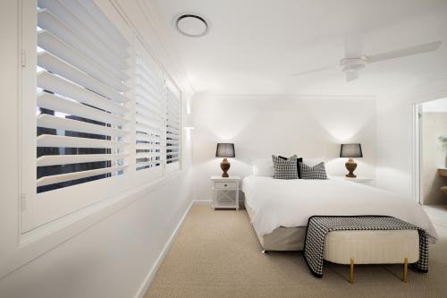 una camera da letto bianca con un letto e una finestra di Urban Haven Central Wagga a Wagga Wagga