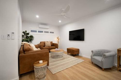 a living room with a couch and a tv at Urban Haven Central Wagga in Wagga Wagga