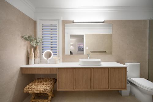 un bagno con lavandino, specchio e WC di Urban Haven Central Wagga a Wagga Wagga