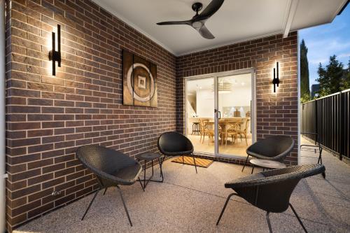 a patio with chairs and a brick wall at Urban Haven Central Wagga in Wagga Wagga
