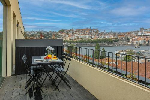 a balcony with a table and chairs on a balcony at Land Roots Riverside Apartments in Vila Nova de Gaia