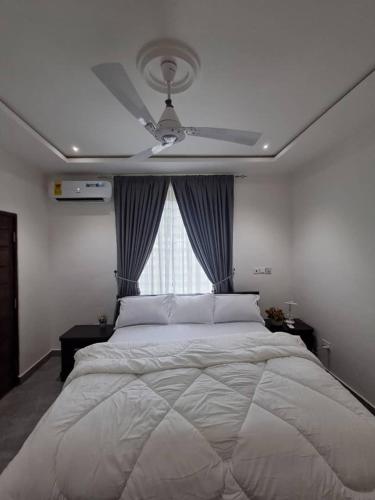 Cosdarl Homes في Midie: غرفة نوم بها سرير كبير ومروحة سقف