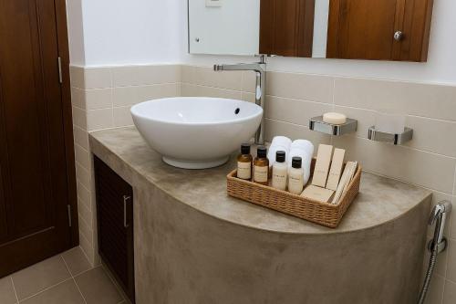 a bathroom with a sink and a basket of soap at Deluxe 4BR Penthouse By Unique Towers in Colombo