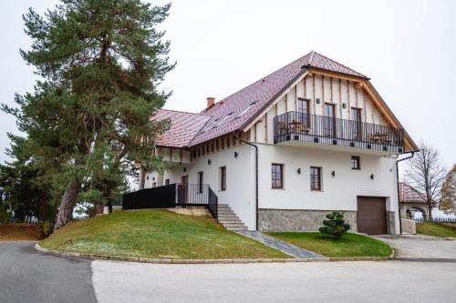 una casa blanca con techo de gambrel en Vineyard Escape Herbersteinova klet, en Juršinci