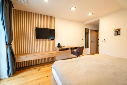 a hotel room with a bed and a desk at Vineyard Escape Herbersteinova klet in Juršinci