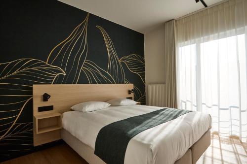 a bedroom with a large bed with a large painting on the wall at Georges Henri Aparthotel in Brussels