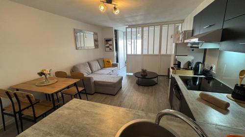 vshome logement cosy 5min gare RER entre Disneyland et Paris في رواسي إن بري: مطبخ وغرفة معيشة مع أريكة وطاولة