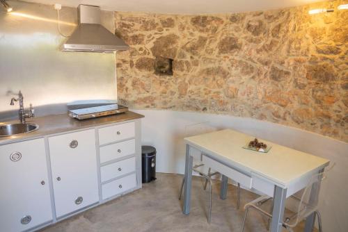 a kitchen with a table and a sink in a room at MoinhoPontoCom in Rio Maior