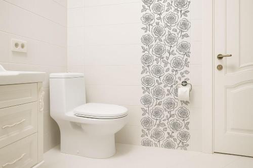 a white bathroom with a toilet and a shower curtain at RR Boutique Hotel in Yerevan