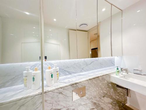 a bathroom with a glass shower and a sink at Burwood Grand Service Apartment in Sydney