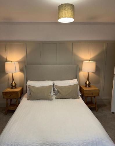 a bedroom with a large bed with two lamps at The OXTED high street studio in Oxted