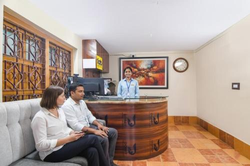 杜尔加布尔FabHotel Sriya - City Center, Durgapur的三个人坐在候诊室里