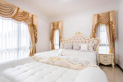 1 dormitorio con 1 cama blanca con marco dorado en Kathu V pool villa 170, en Ban Kathu (1)