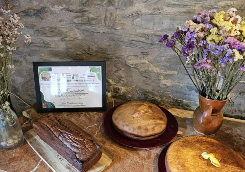 Una mesa con un poco de pan y un jarrón con flores. en Hotel Rural La Encantada en Riaza, en Becerril