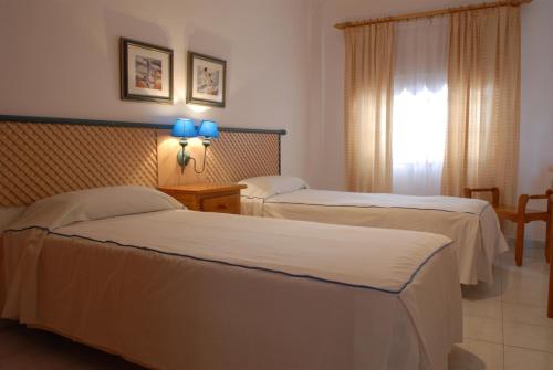 Una habitación de hotel con dos camas y una ventana. en Playa Delphin 304, en Puerto Naos