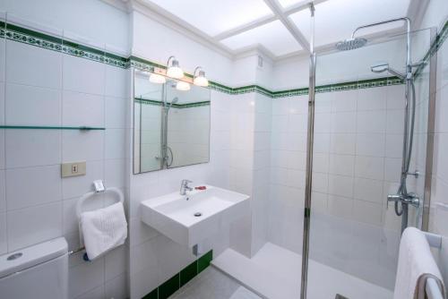 Un baño blanco con lavabo y ducha en Playa Delphin 303, en Puerto Naos