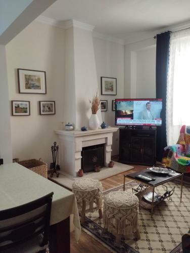 a living room with a fireplace and a flat screen tv at Blue Castle House in Gouveia