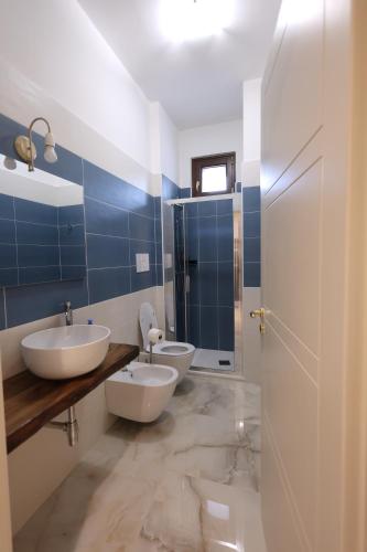 a bathroom with two sinks and blue tiles at Albergo Peluso in Altavilla Irpina