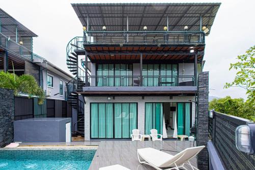 a house with a swimming pool next to a building at Kathu V pool villa 170 in Kathu