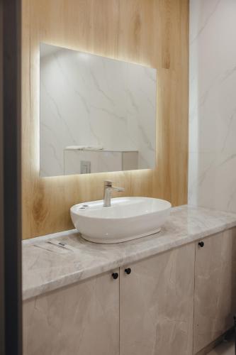 a bathroom with a white sink and a mirror at Asad in Astana