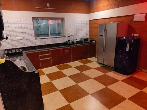 una cucina con frigorifero e pavimento a scacchi di Private Nature Bungalow with Large Outdoor Area a Kankanādi