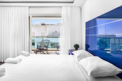 Un dormitorio con una cama y una ventana grande. en מילה דירות אירוח - Skyline Eilat, en Eilat