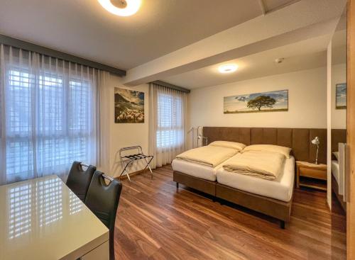a bedroom with a bed and a table and chairs at Hotel Hecht in Rheineck