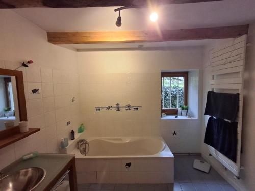 a bathroom with a tub and a sink at Chambres d'hôtes des Deux Lacs in Ceyzérieu