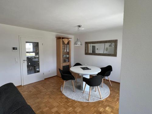 Una sala de estar con una mesa y sillas blancas. en Ferienwohnung Arnold, en Leutkirch im Allgäu