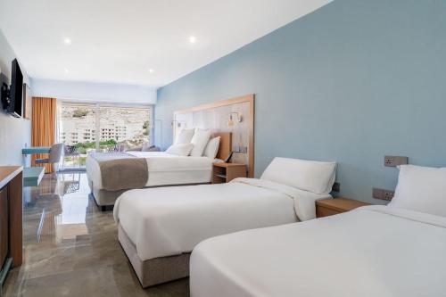 Ένα ή περισσότερα κρεβάτια σε δωμάτιο στο Reef Hotel & Spa