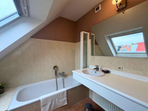 ein Badezimmer mit Badewanne und Waschbecken in der Unterkunft Le Charming duplex lumineux avec balcon, terrasse ensoleillée & parking in Knokke-Heist