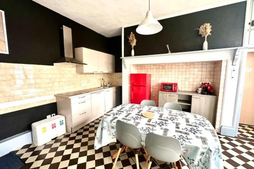 a kitchen with a table and chairs in a kitchen at La Maison d'Anissa-plage à 20min-Wifi-Parking in Nouvion-en-Ponthieu