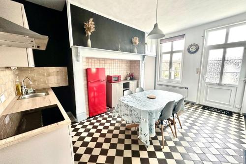a kitchen with a table and a red refrigerator at La Maison d'Anissa-plage à 20min-Wifi-Parking in Nouvion-en-Ponthieu