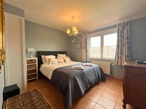 ein Schlafzimmer mit einem Bett mit zwei Handtüchern darauf in der Unterkunft Le Charming duplex lumineux avec balcon, terrasse ensoleillée & parking in Knokke-Heist