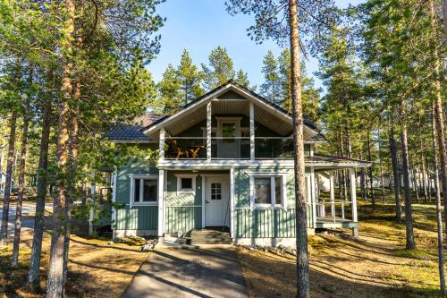 una casa verde nel bosco con alberi di Jukuheikki a Kalajoki