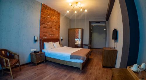 a bedroom with a bed and a chair in it at TM Apart Hotel in Tbilisi City