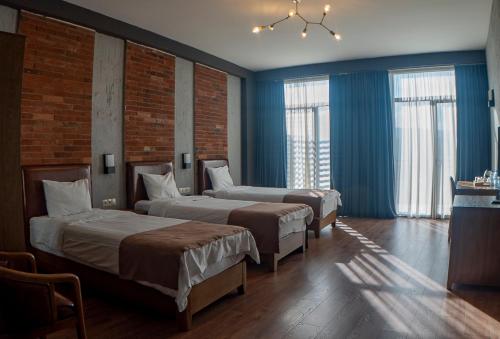two beds in a room with blue walls and windows at TM Apart Hotel in Tbilisi City