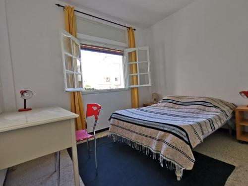 Oasis de calme Sousse centre في Bin Rhilouf: غرفة نوم بها سرير ومكتب ونافذة