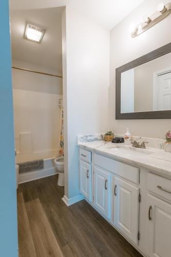 a bathroom with a sink and a mirror at 3 Bed Townhouse with King Bed Mins from Downtown in Shreveport