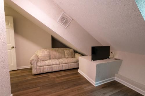 a living room with a chair and a tv at 3 Bed Townhouse with King Bed Mins from Downtown in Shreveport