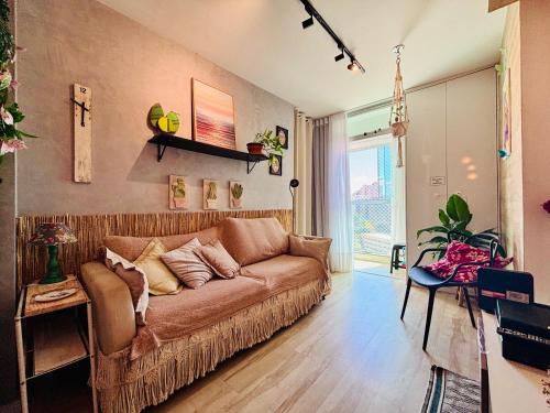 una sala de estar con un sofá marrón en una habitación en Ap completo com ar e garagem coberta próximo ao metrô, en Brasilia