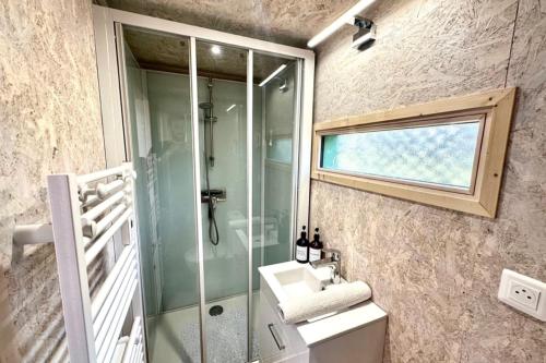 a bathroom with a glass shower and a sink at Les 1000 Ailes-Expérience Unique dans une Hutte in Le Crotoy