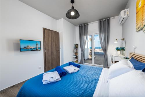 a bedroom with a blue bed with a view of the ocean at Gennadi Villa Mary in Gennadi